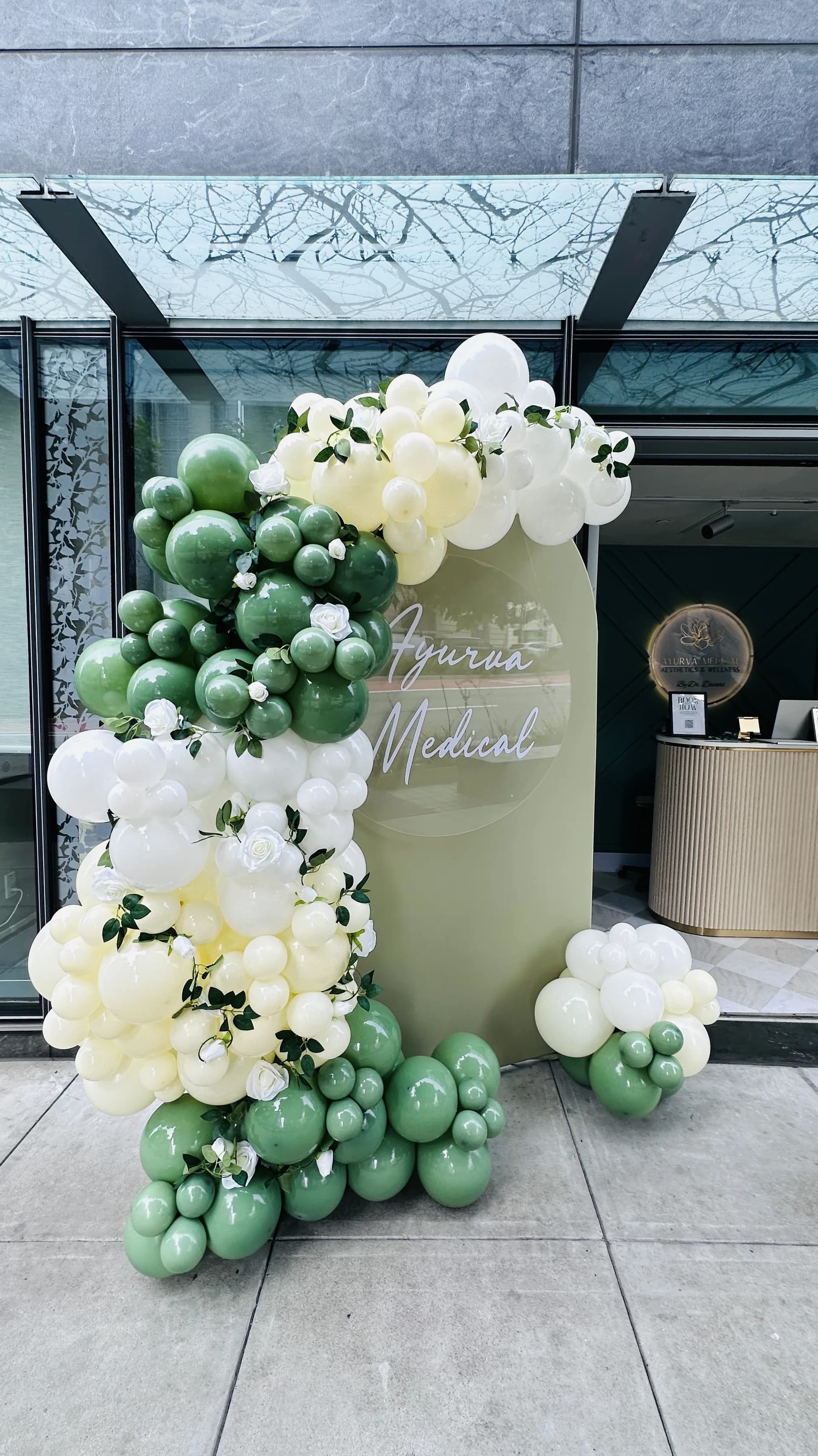 Organic balloon arch and branded backdrop at the Salon Grand Opening in San Francisco, California.