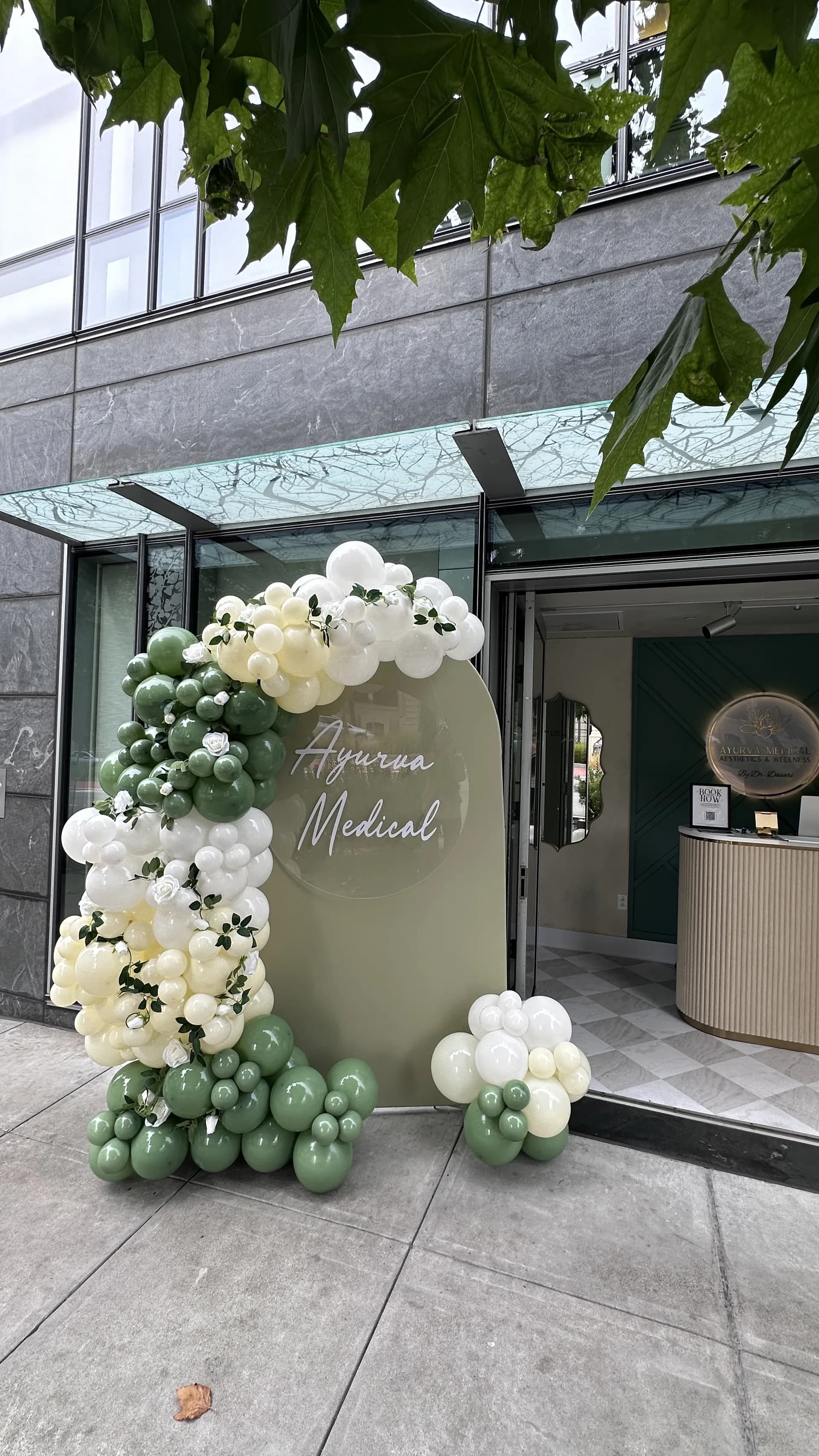 Completed organic balloon arch and branded backdrop from the Salon Grand Opening project in San Francisco, California (image 4 of 8).