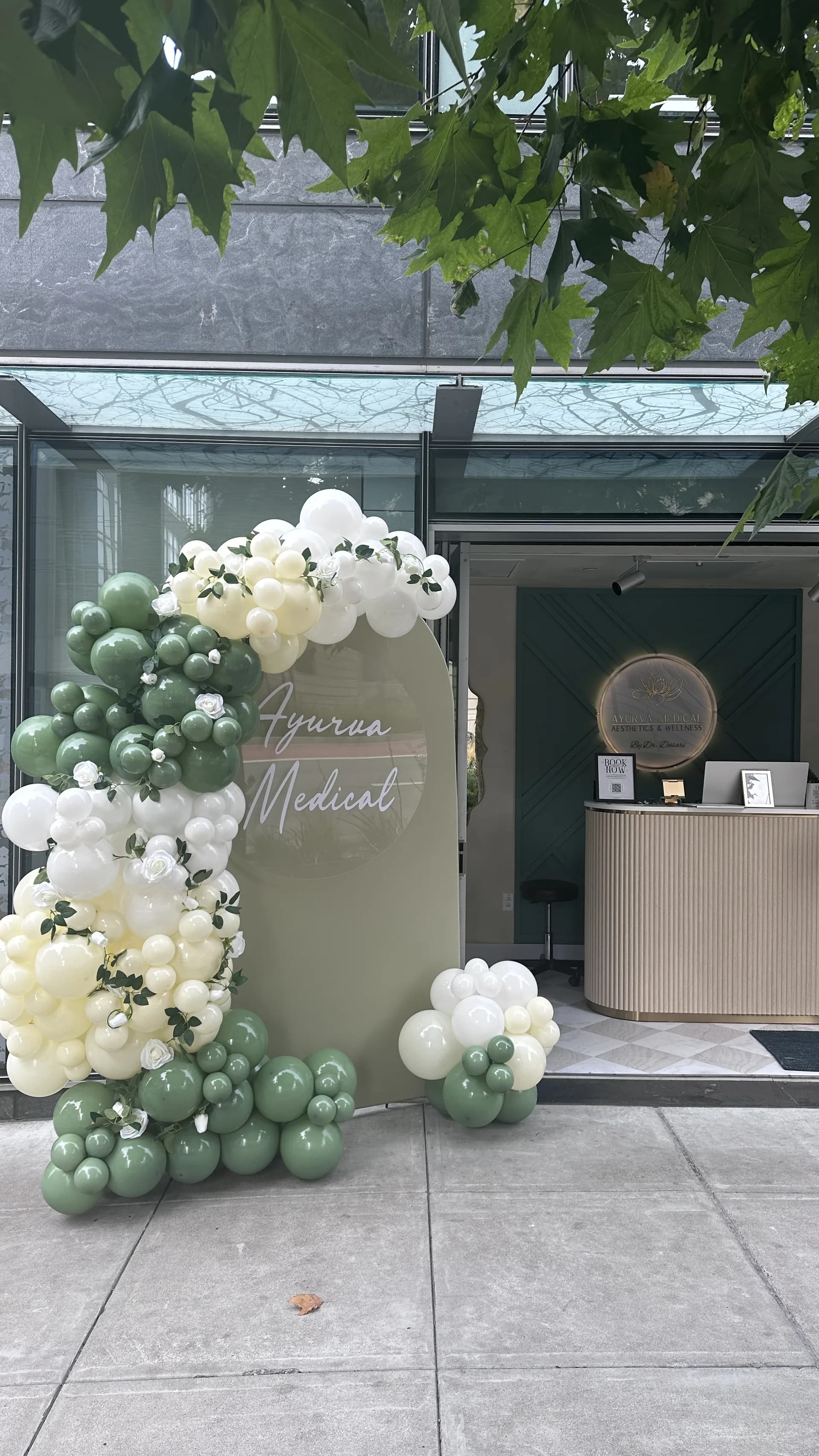 Organic balloon arch and branded backdrop installed on site for the Salon Grand Opening in San Francisco, California, frame 5 of 8.