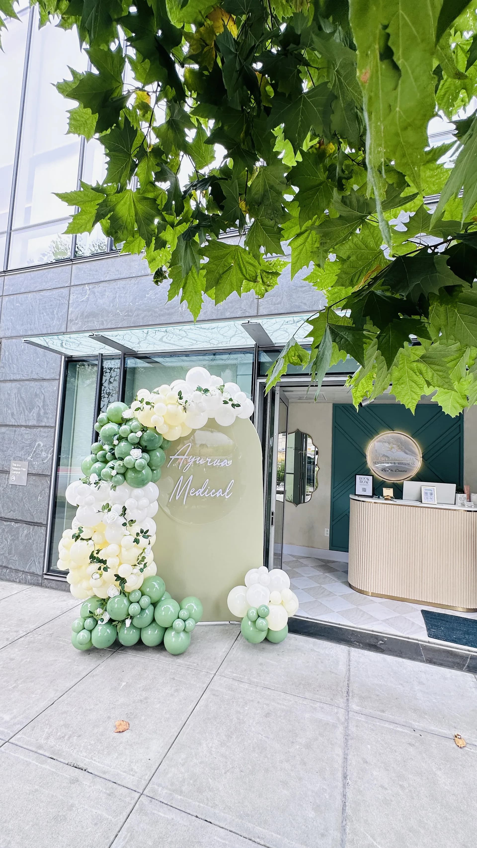 Corporate event décor by Balloon Décor: organic balloon arch and branded backdrop in sage green, ivory and white, San Francisco, California — view 6.