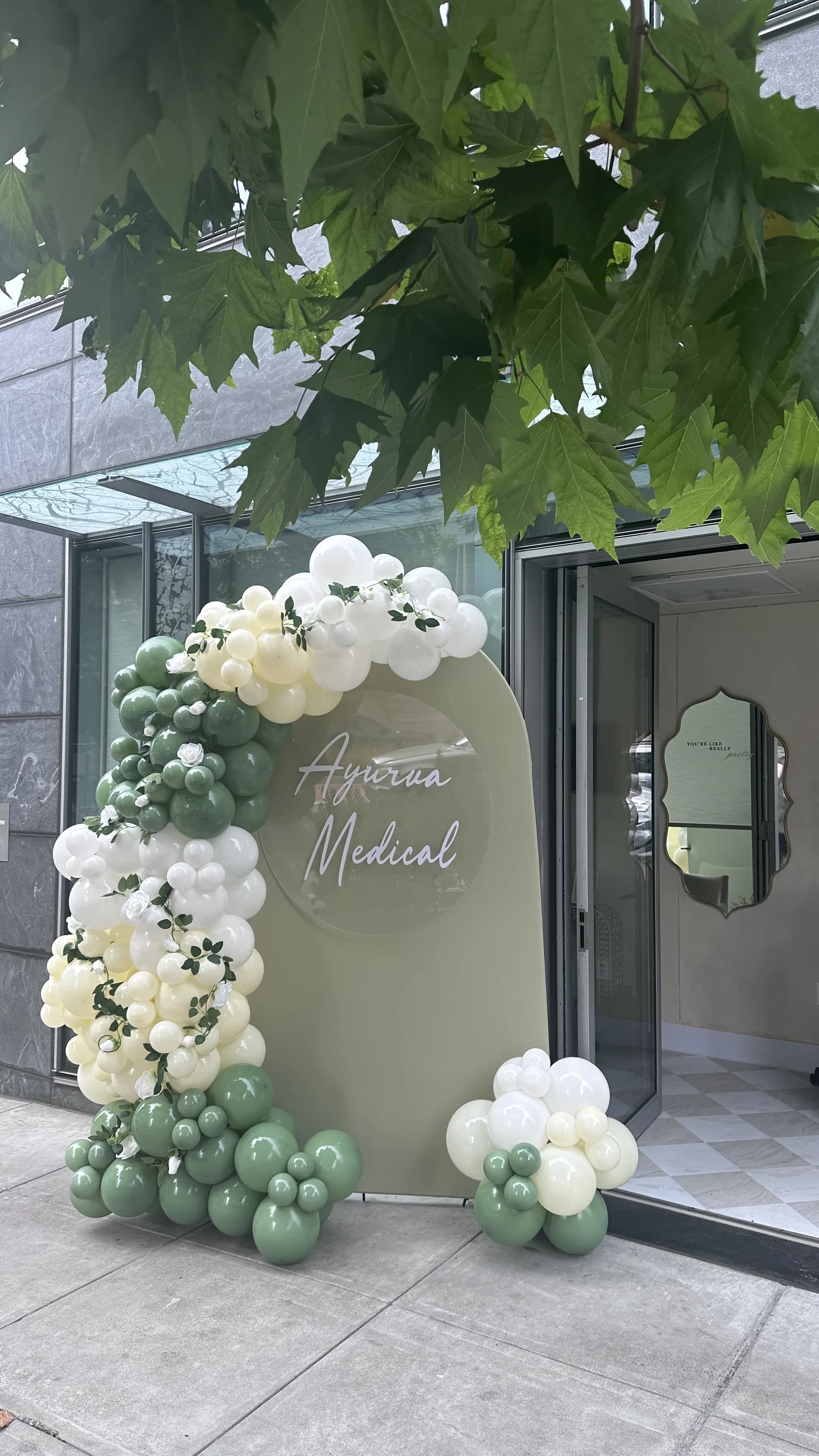 Organic balloon arch and branded backdrop in sage green, ivory and white, Salon Grand Opening, San Francisco, California — view 7 of 8.