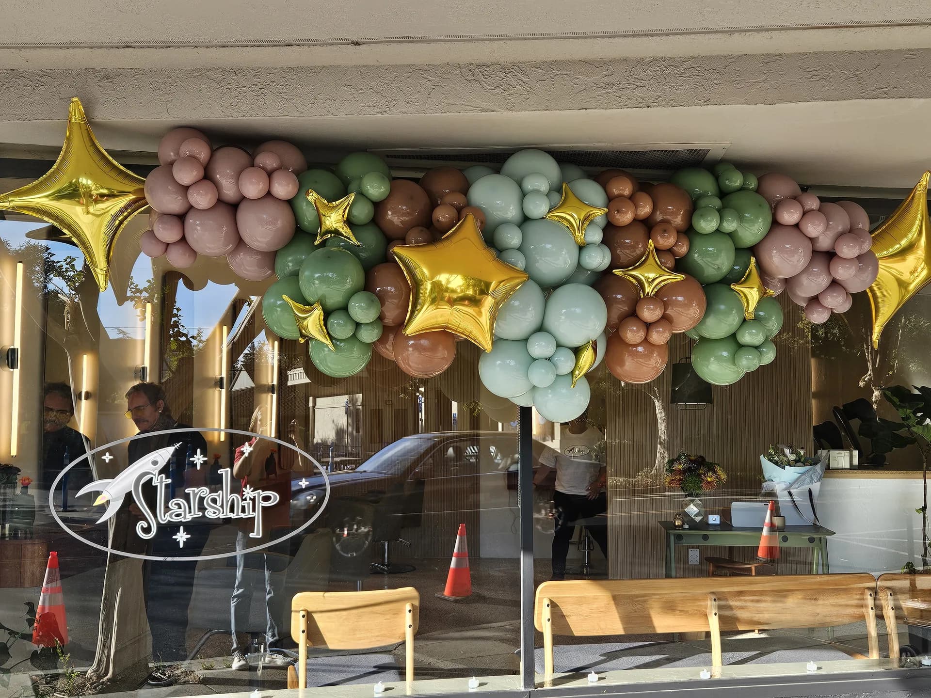 Storefront balloon garland with gold star accents at the Salon Grand Opening in San Carlos, California.