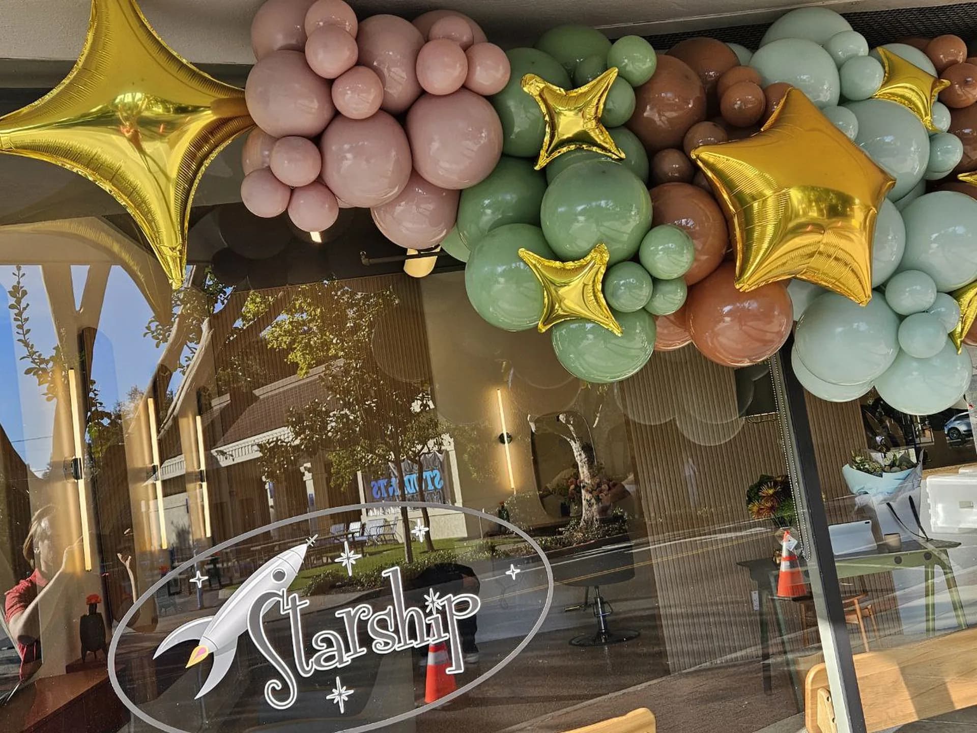 Storefront balloon garland with gold star accents produced by Balloon Décor for a corporate client in San Carlos, California, view 3.