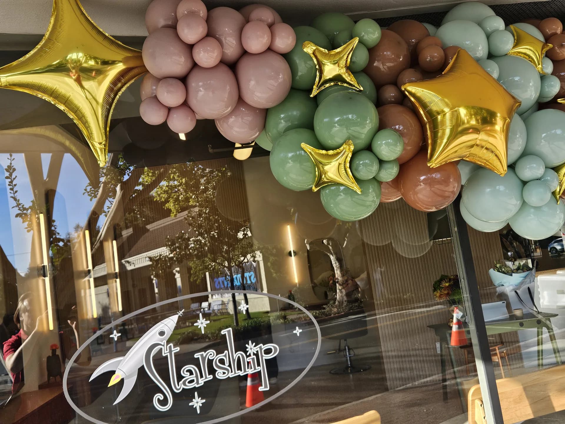 Completed storefront balloon garland with gold star accents from the Salon Grand Opening project in San Carlos, California (image 4 of 5).