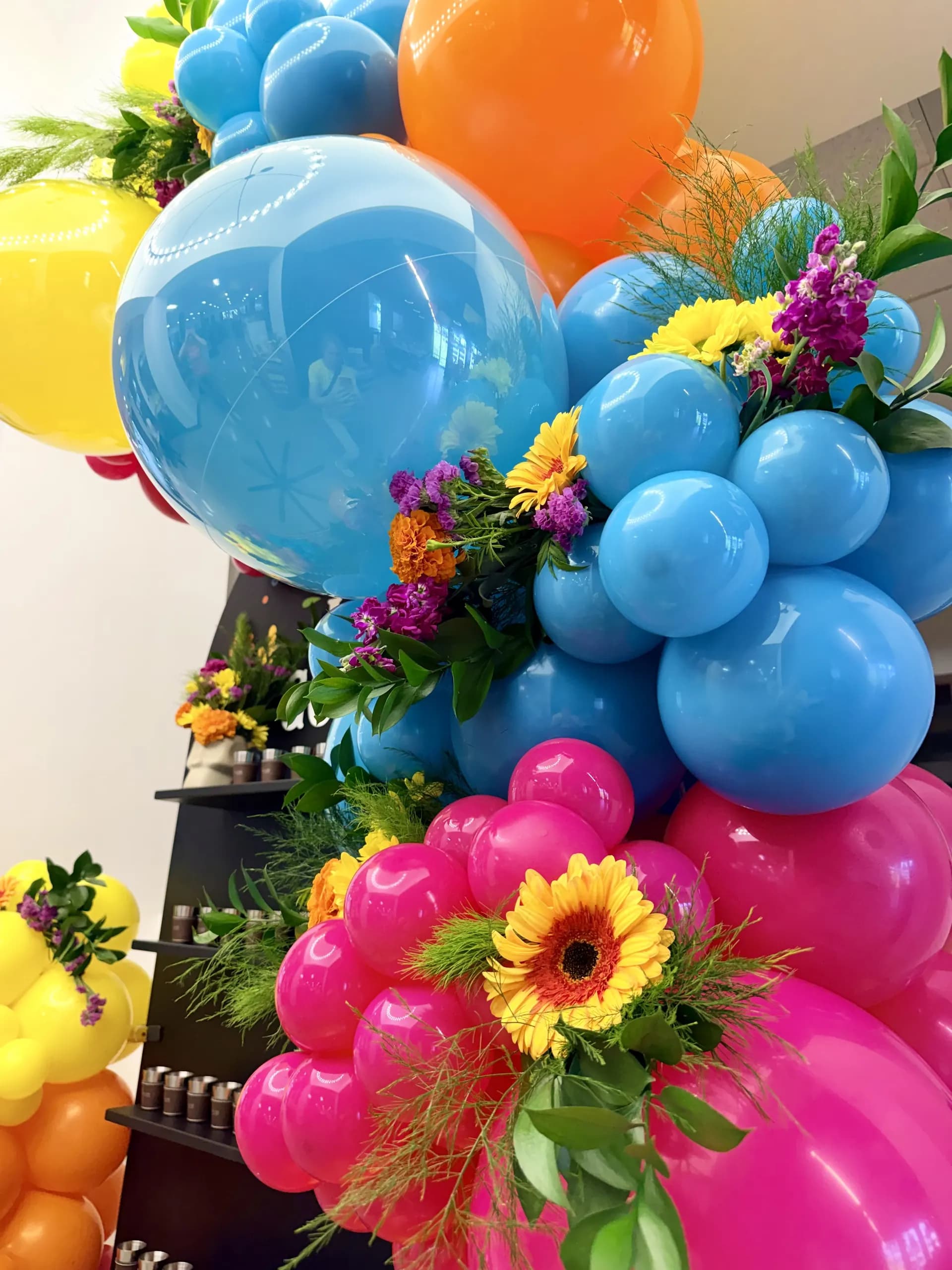 Balloon photo zone with fresh flowers and centerpieces installed on site for the Office Celebration in San Jose, California, frame 5 of 8.