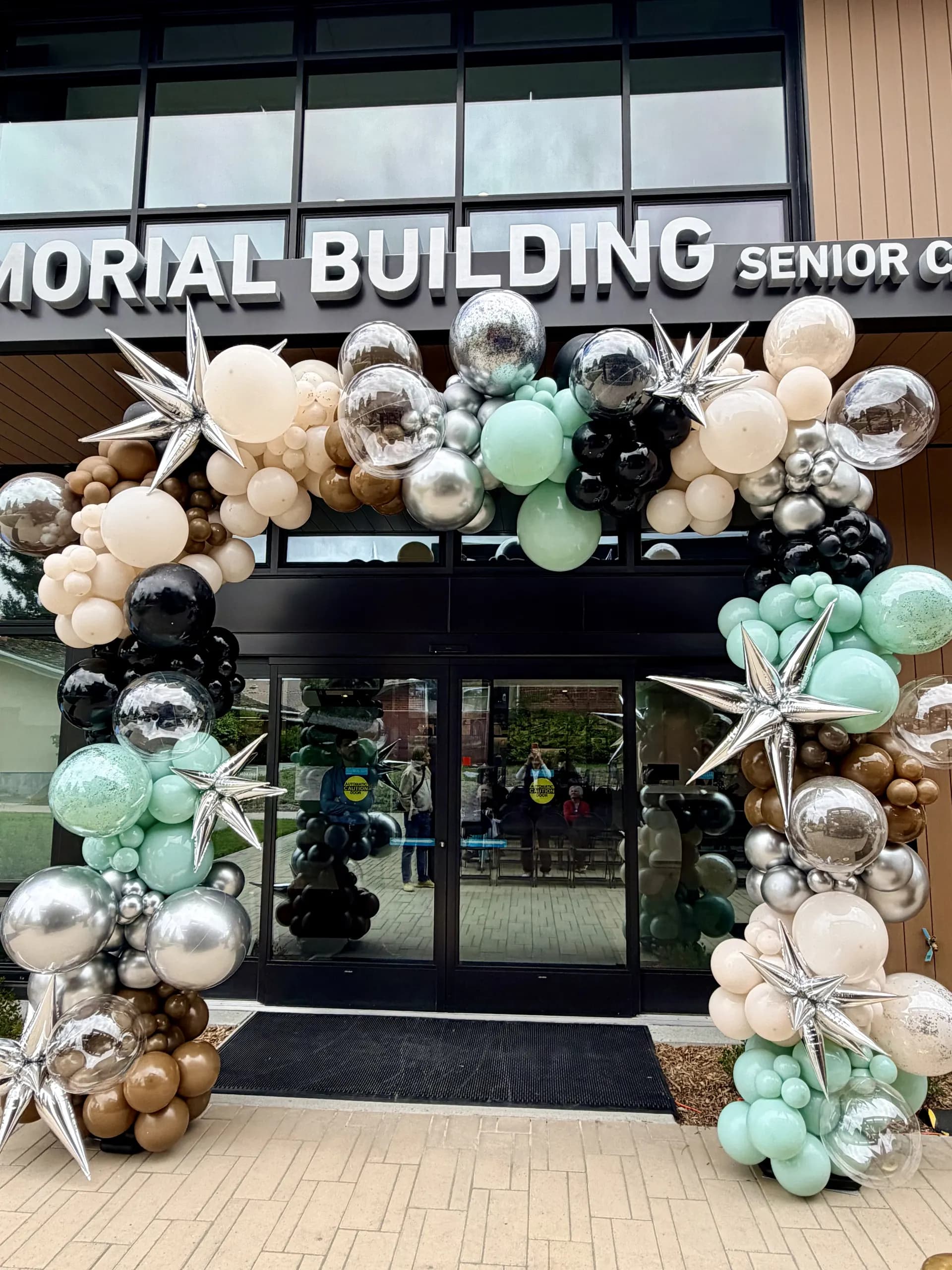 Large-scale entrance balloon arch and interior balloon installation for Redwood City Veterans Memorial Senior Center at the Grand Opening in Redwood City, California.
