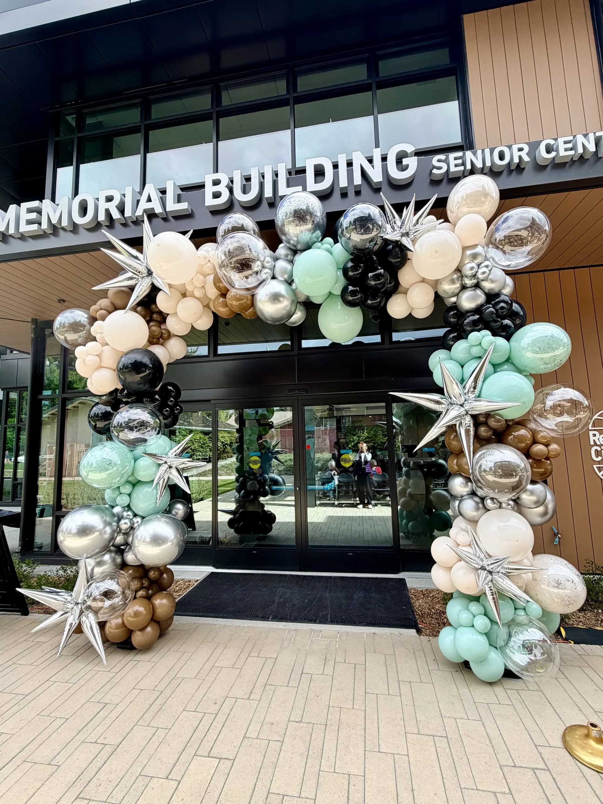 Large-scale entrance balloon arch and interior balloon installation produced by Balloon Décor for Redwood City Veterans Memorial Senior Center in Redwood City, California, view 3.
