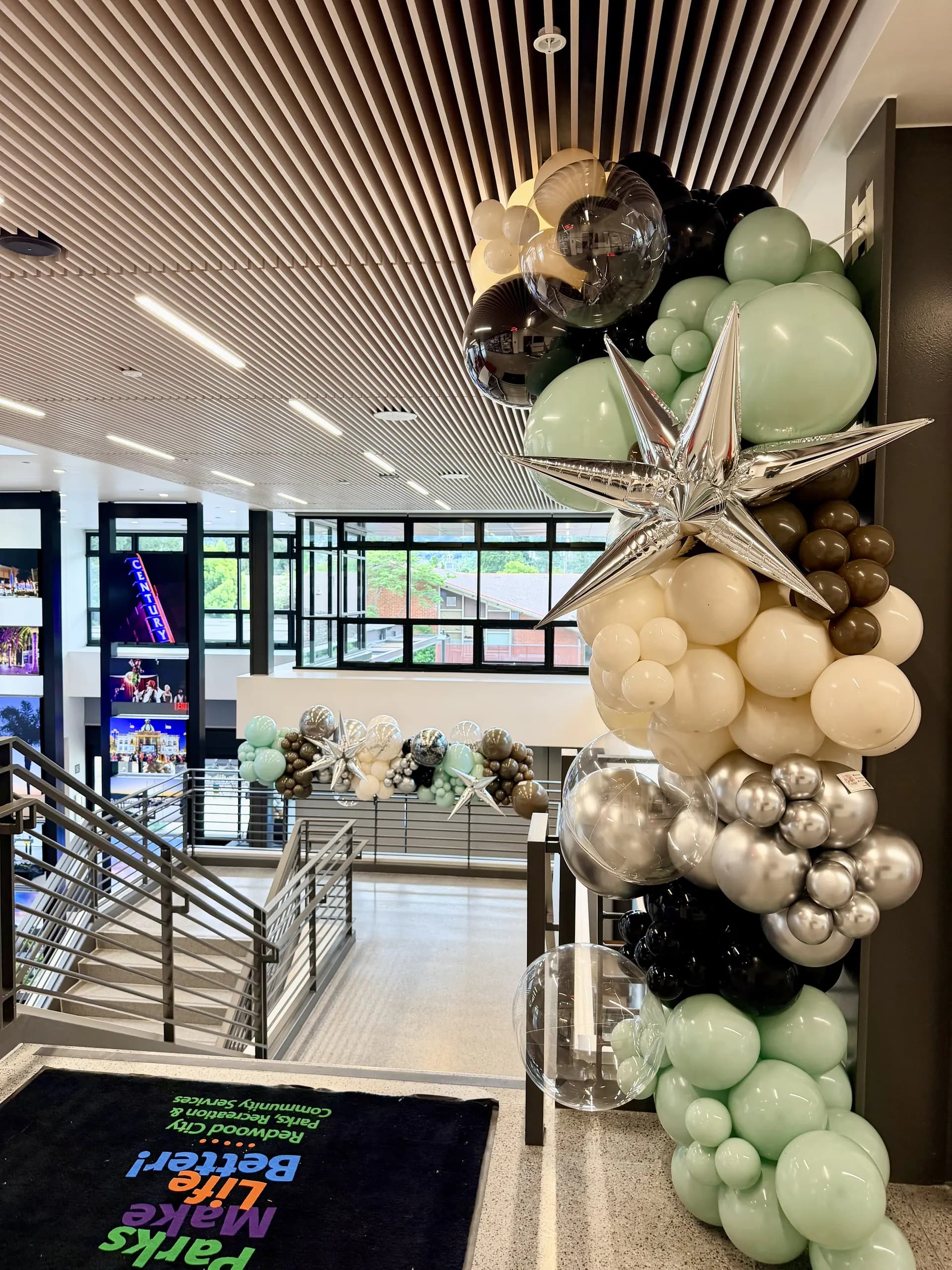 Large-scale entrance balloon arch and interior balloon installation installed on site for the Grand Opening in Redwood City, California, frame 5 of 8.